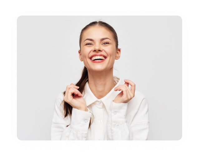 Smiling woman holding a clear aligner